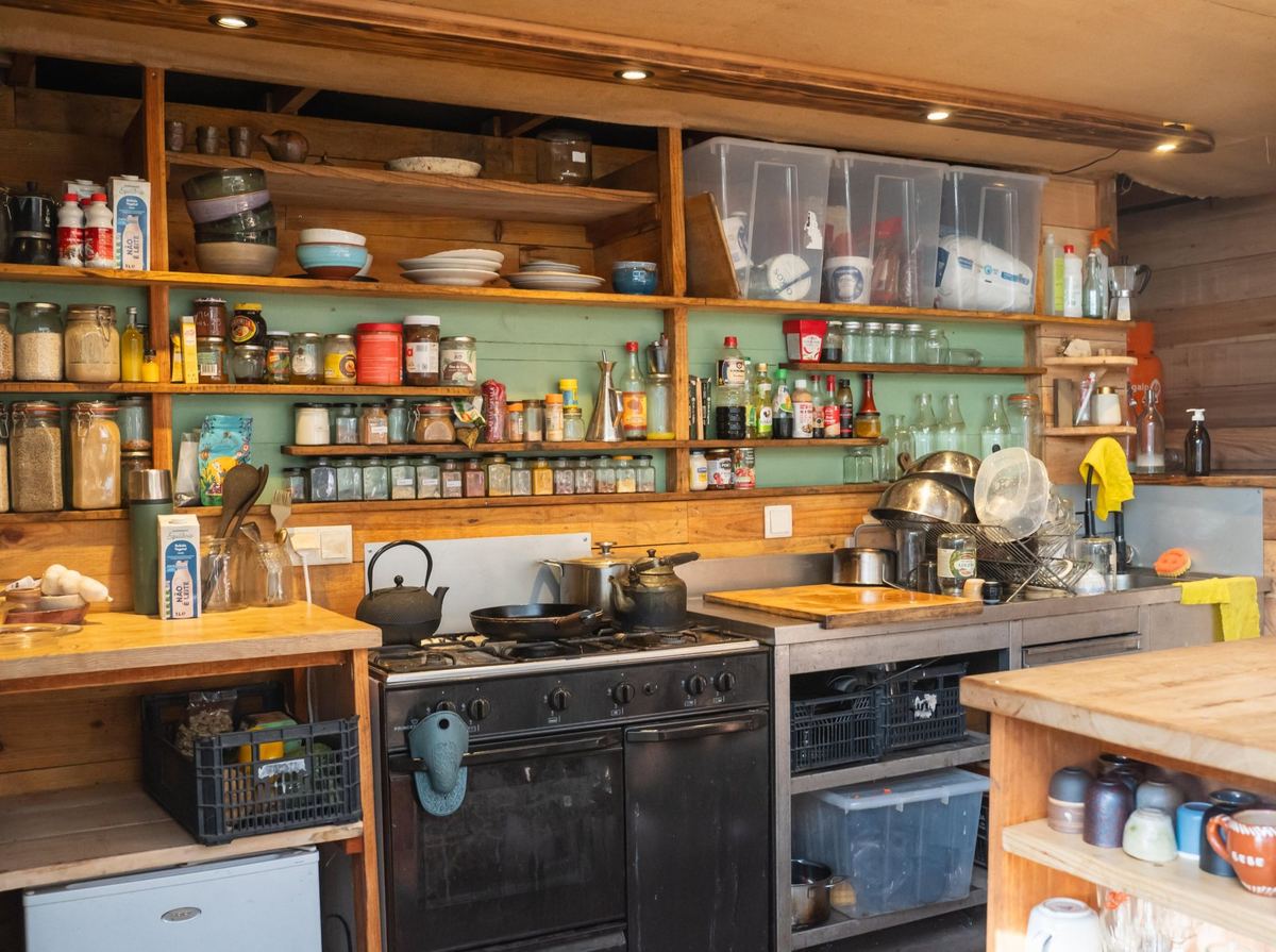The communal kitchen: shelves of jars and spices above a gas range and oven