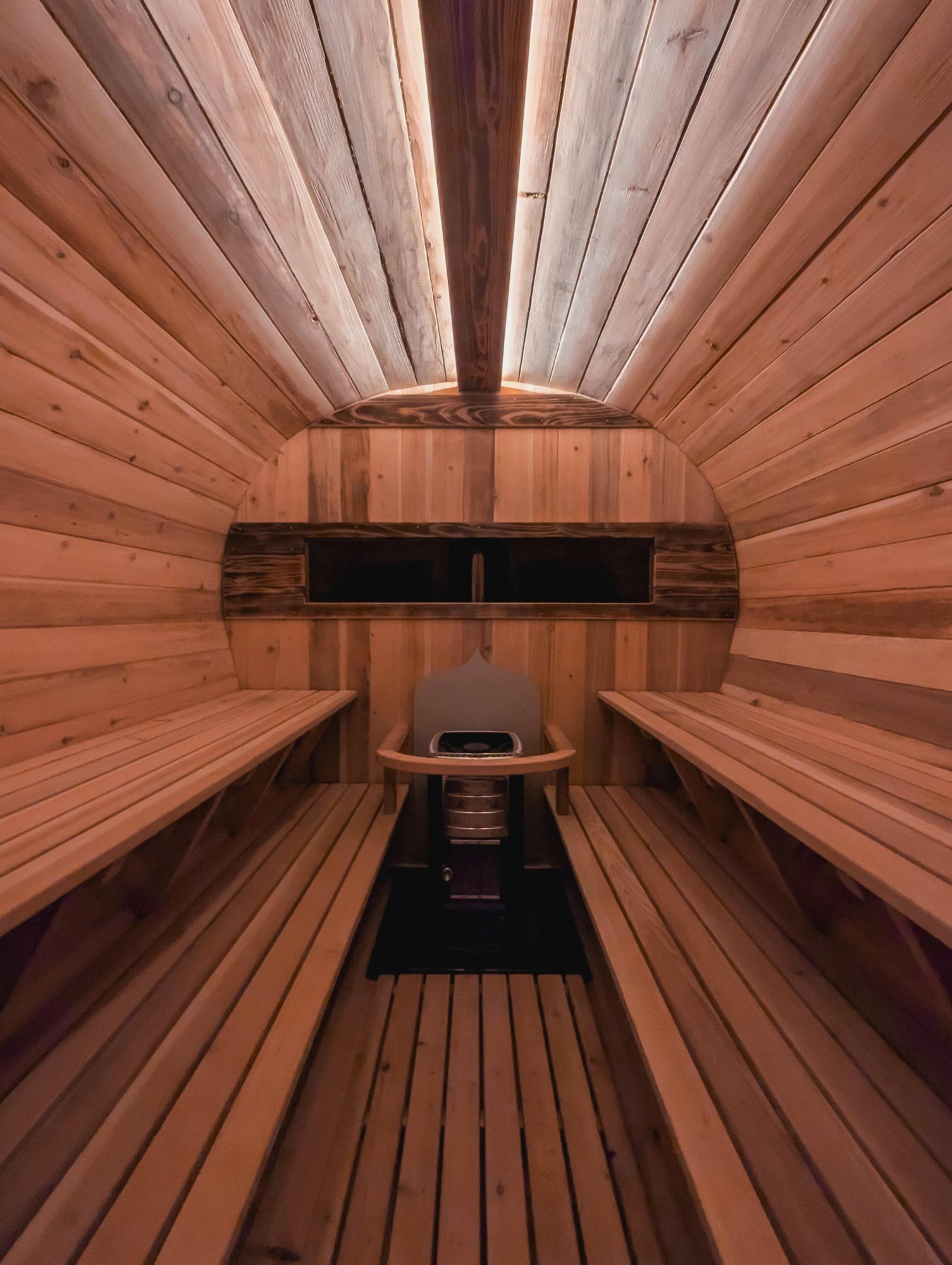 Inside the cedar sauna, benches either side of the stove
