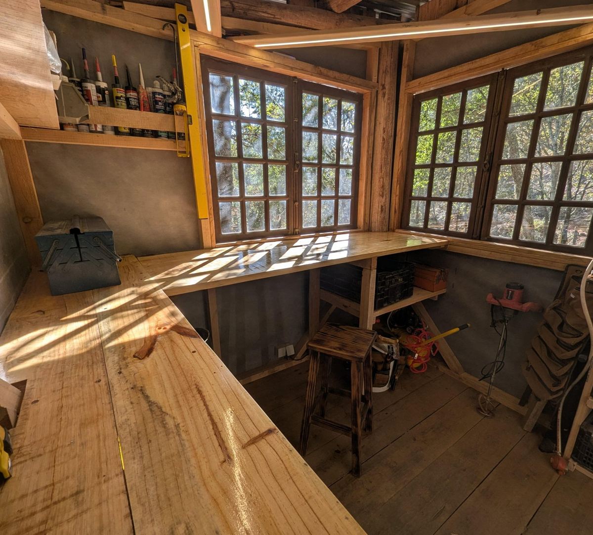 The workshop: long timber benches in sunlight under multi-pane windows