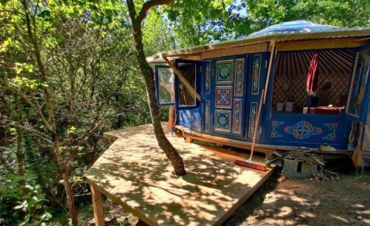 The Mongolian yurt and its deck among the trees